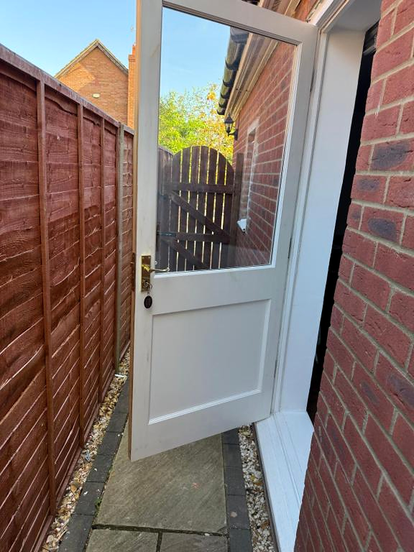 White entrance door set in a brick boundary wall