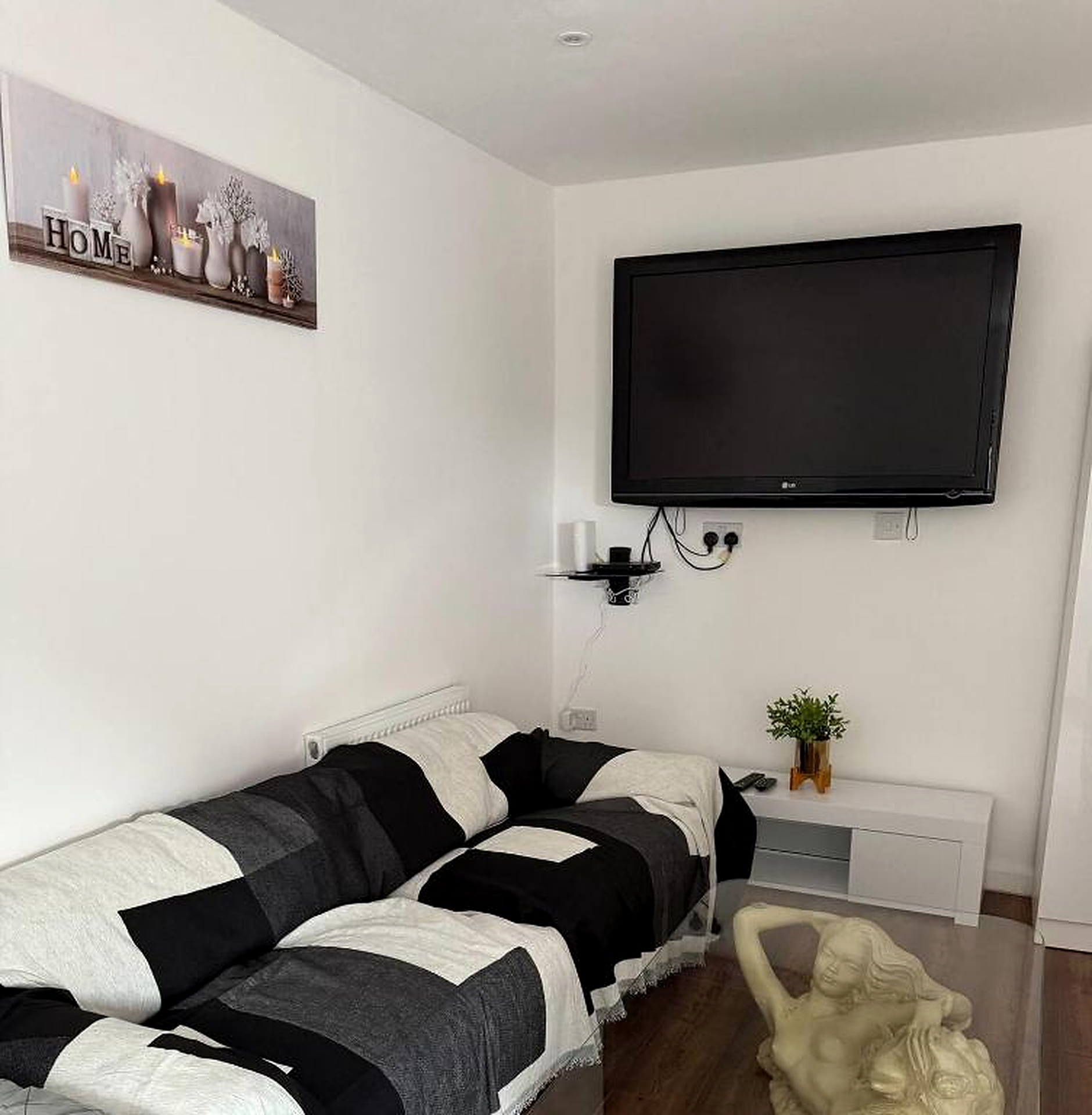 Living room with a black and white sofa and flat-screen TV