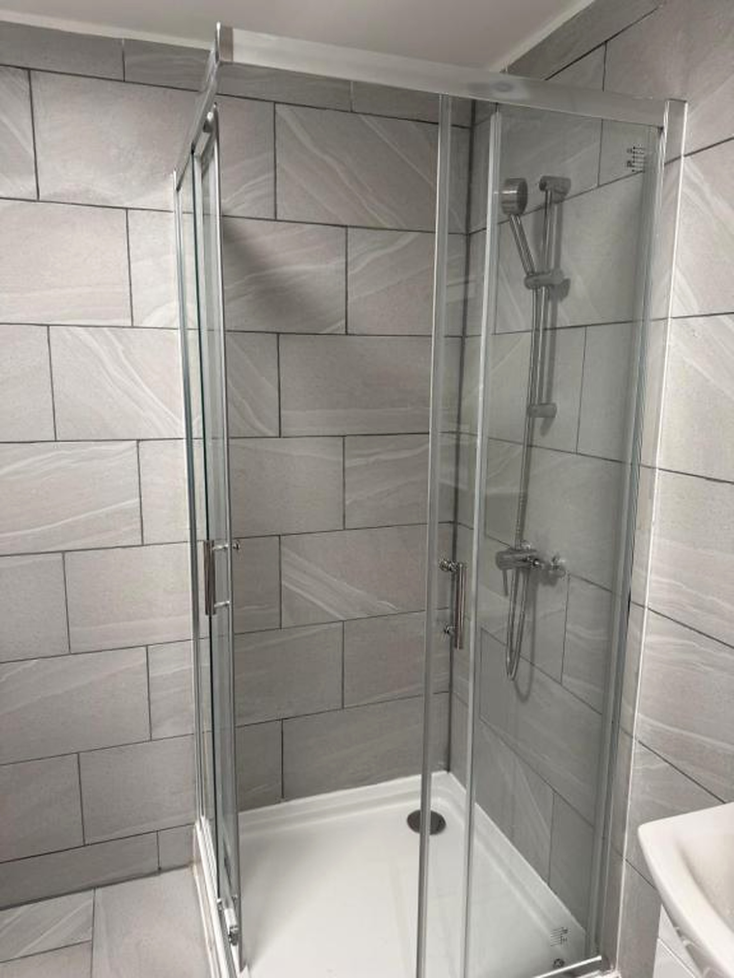 Walk-in shower with tiled walls and glass screen